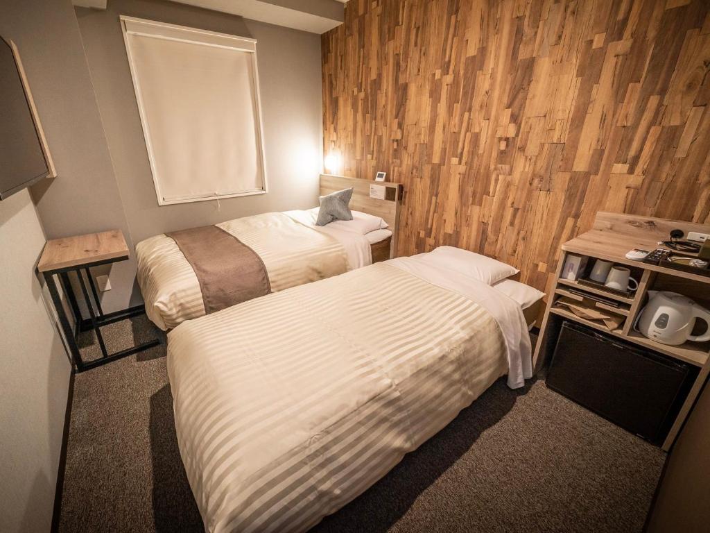 Postel nebo postele na pokoji v ubytování Super Hotel Premier Namba Shinsaibashi Natural Hot Spring