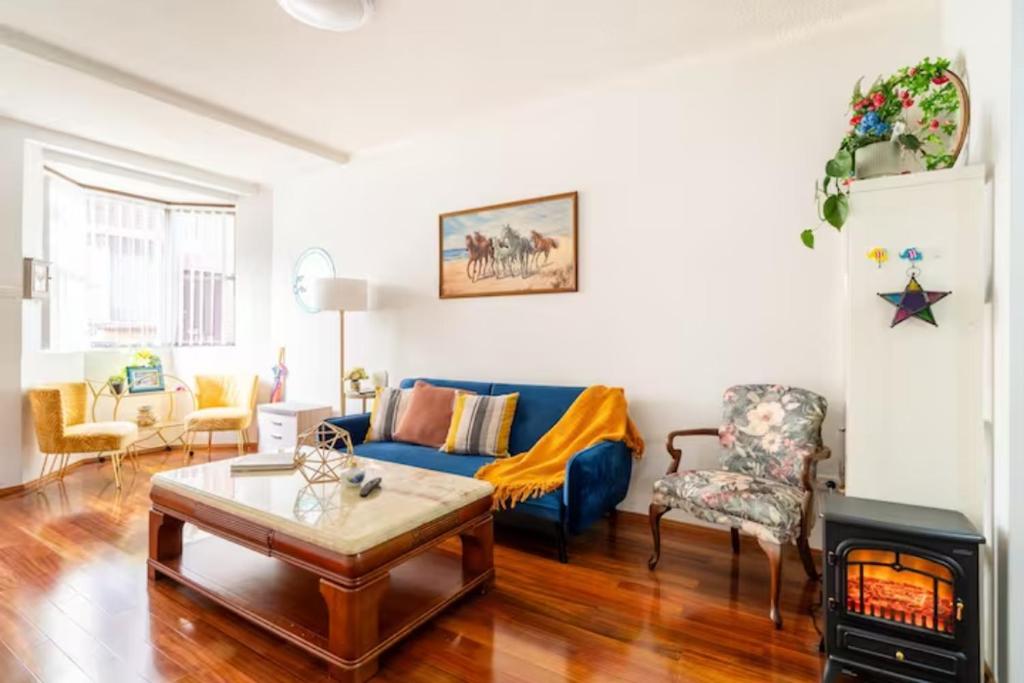 een woonkamer met een blauwe bank en een open haard bij Culture Paradise 3BR 2 story Townhouse Cabramatta in Cabramatta