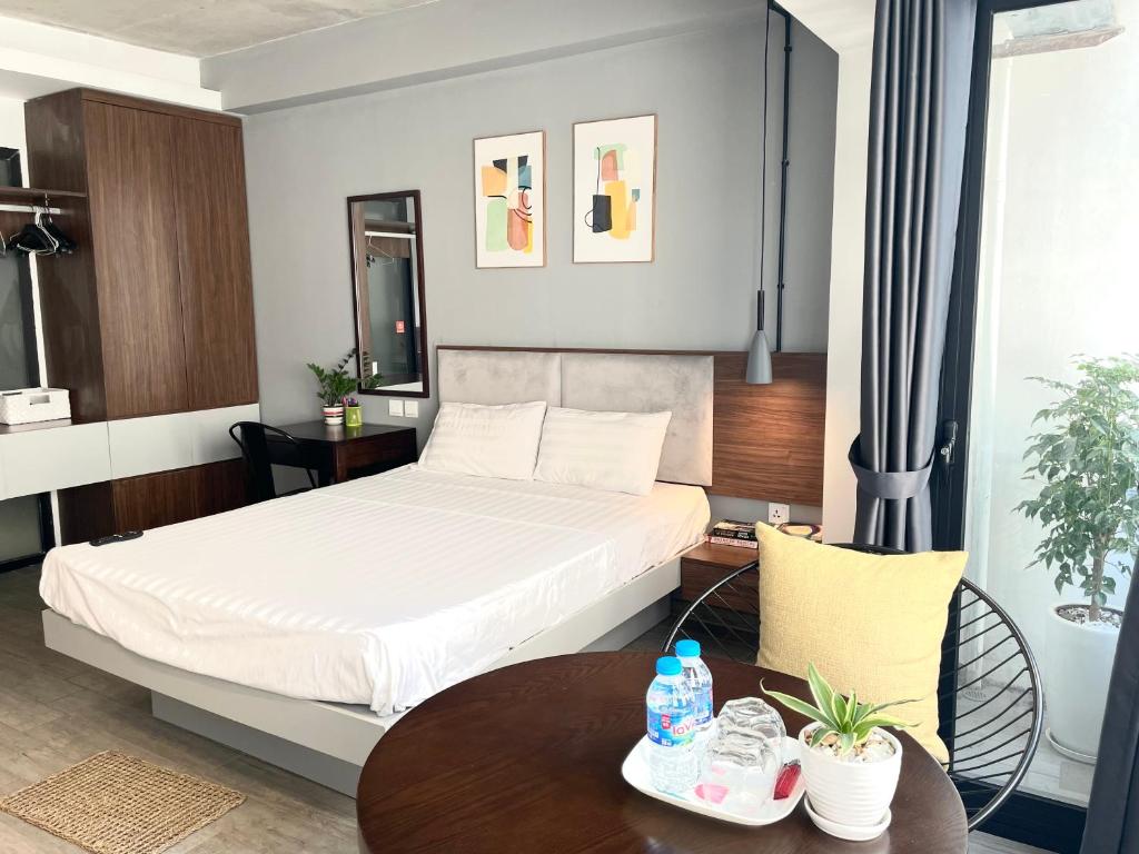 une chambre d'hôtel avec un lit et une table dans l'établissement Kem Apart 01, à Hanoï