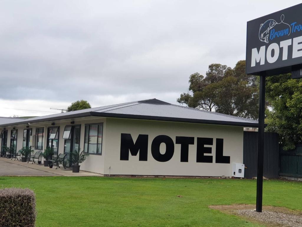a motel building with a sign in front of it at Brown Trout Motel in Pahiatua