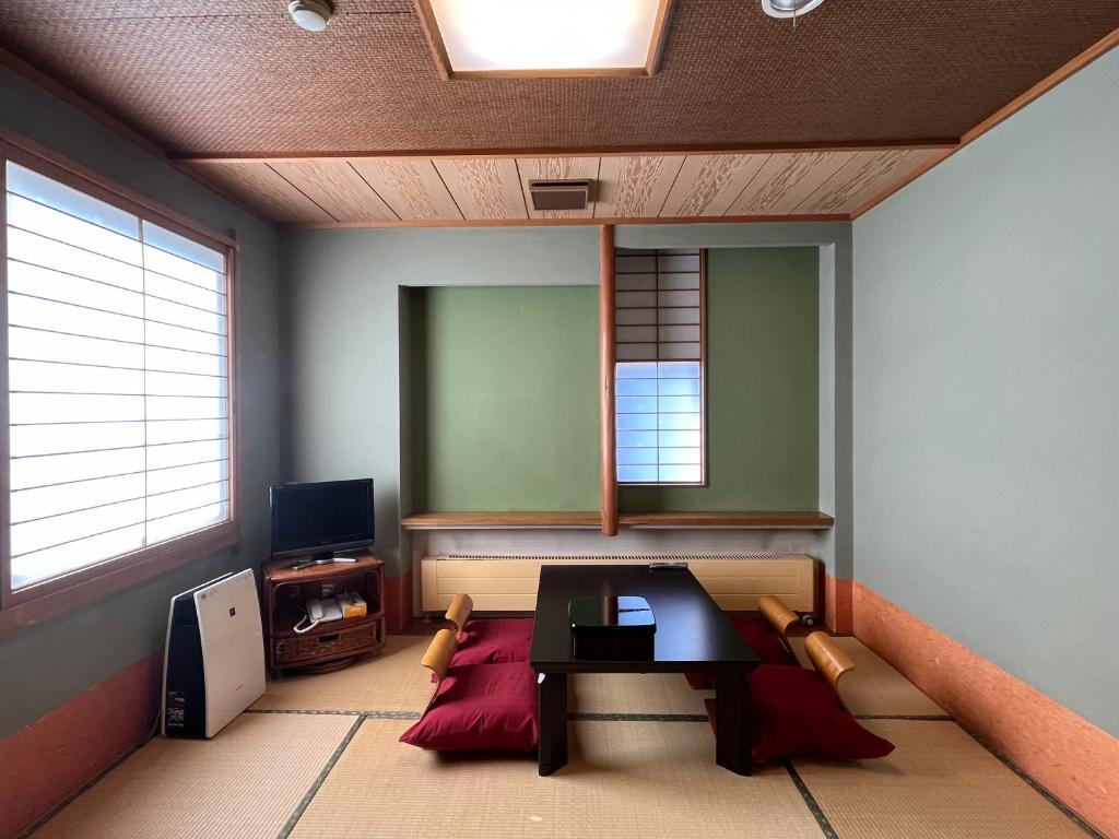 a living room with a table and a mirror at Pension Puutaro in Zao Onsen