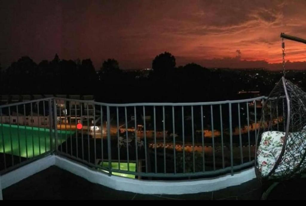 a balcony with a view of a city at night at Cinta Hati Homestay Crystal Creek Apartment Taiping in Taiping