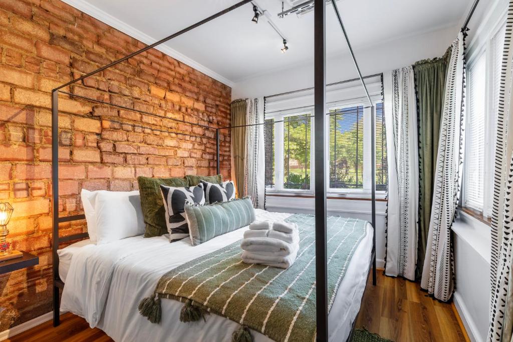 een slaapkamer met een bed en een bakstenen muur bij Modern Century Loft At The Pillars in Cleveland