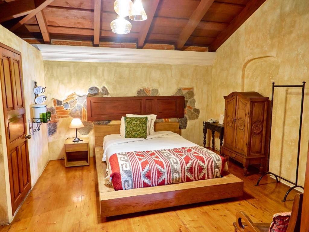 a bedroom with a bed and a dresser in it at Naif Boutique Hotel in Antigua Guatemala