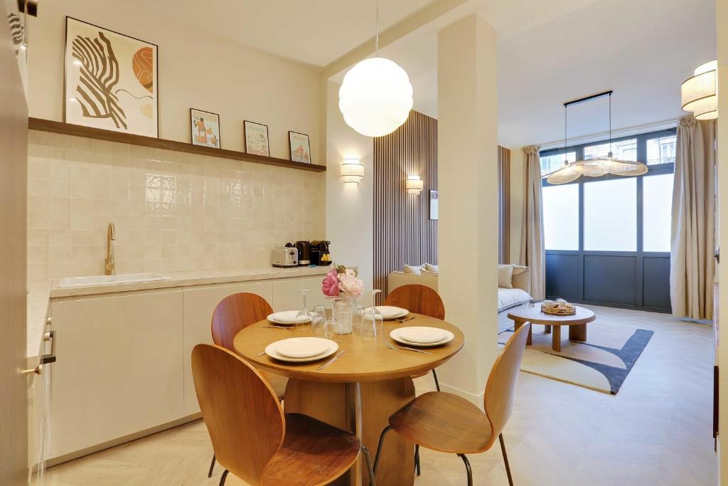 Superbe appartement 6P2BR - Montmartre في باريس: مطبخ وغرفة طعام مع طاولة وكراسي