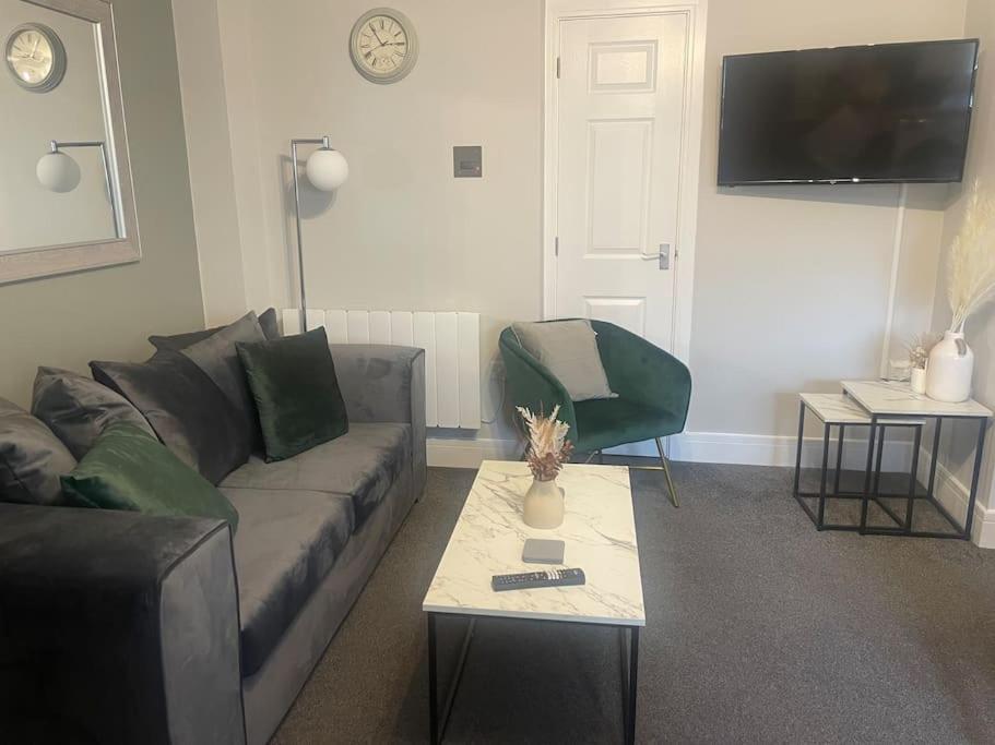 a living room with a couch and a table at Fern House - 2bedroom house Free Parking Town centre by Shortstays4u in King's Lynn