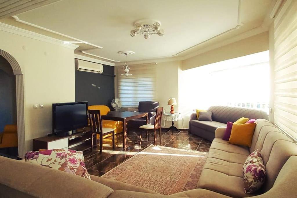 Уютная квартира в Ялове في Koruköy: غرفة معيشة مع أريكة وطاولة