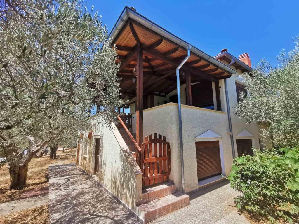une maison avec une terrasse couverte en bois et une clôture dans l'établissement Villa Elli, à Alexandroúpolis