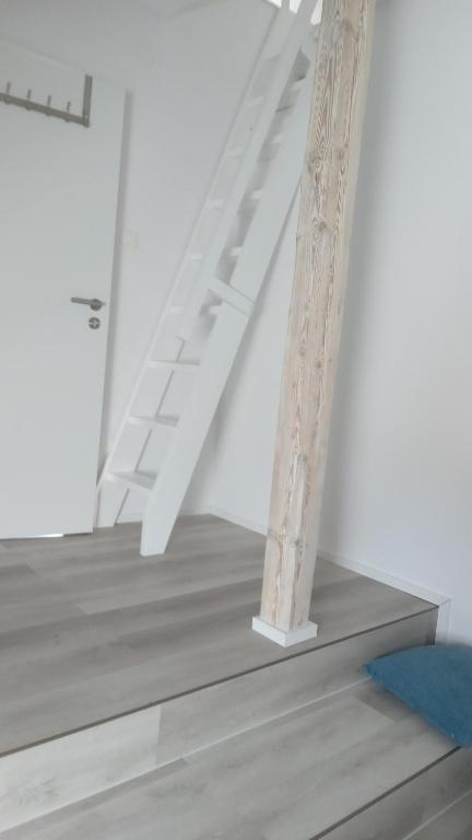 a white staircase in a white room with a ladder at ROYAL APARTMENTS in Lunca de Sus