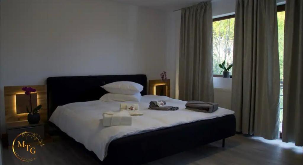 a bedroom with a bed with white sheets and pillows at Montagnoli Luxury Villa in Cluj-Napoca