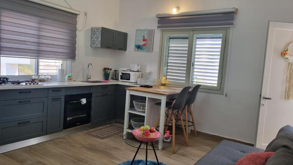 una cocina con armarios azules y una mesa en una habitación en Stylish Quiet and Central en Rechovot