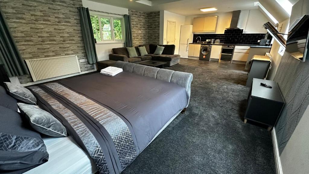 a bedroom with a large bed and a living room at Peaceful LARGE Studio Flat Colchester in Colchester