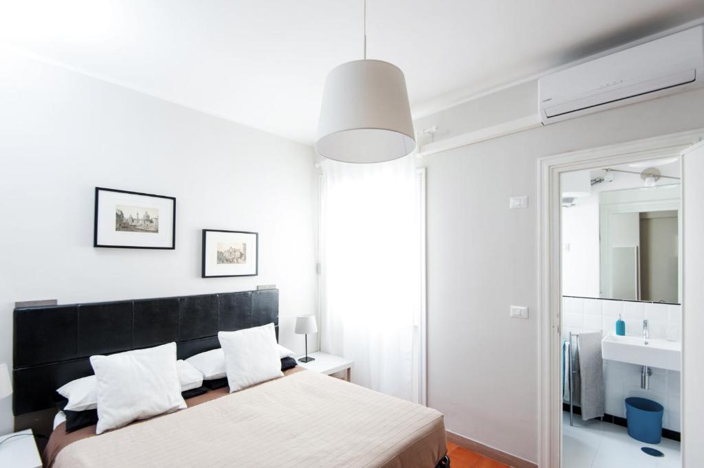 a white bedroom with two beds and a mirror at La Lanterna Di San Pietro in Rome