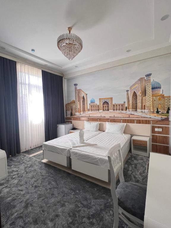 a bedroom with a large bed and a chandelier at Oqshom Plaza Hotel in Qarshi