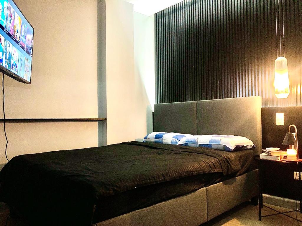 a bedroom with a bed and a tv in it at Cozy Room, Study Space & Bathtub in Manila