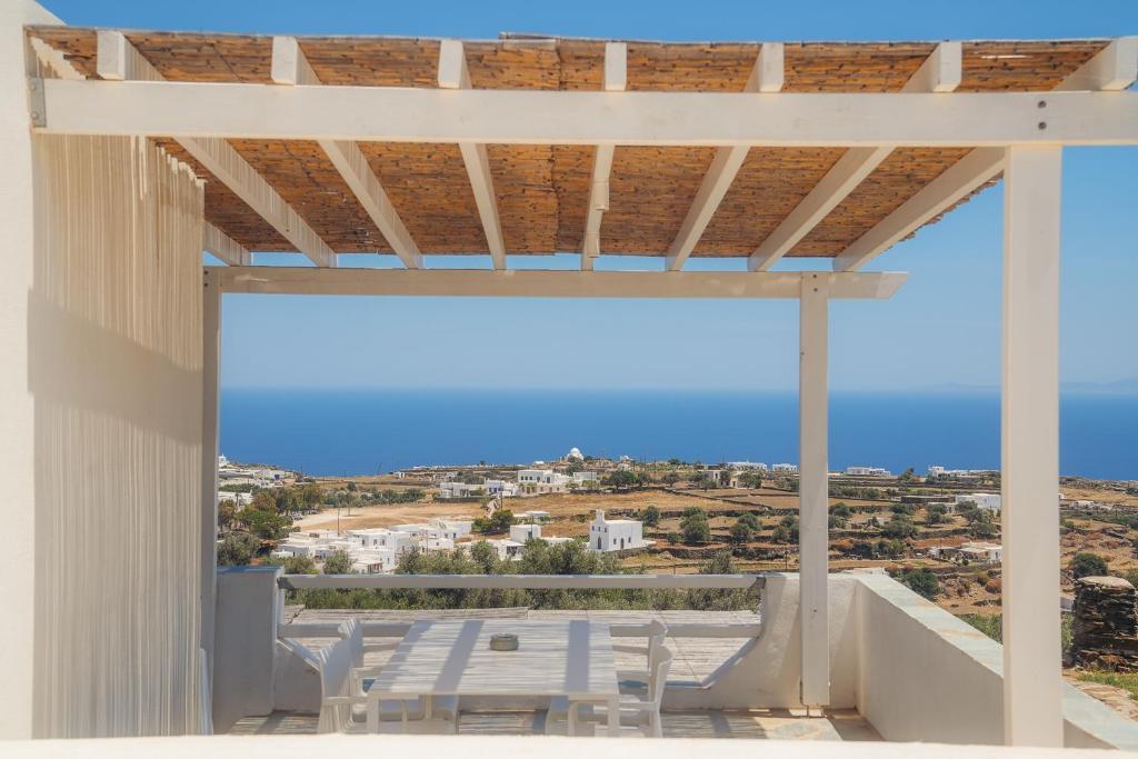 a view from the balcony of a house with white chairs at NiMa Sifnos Residences in Apollonia