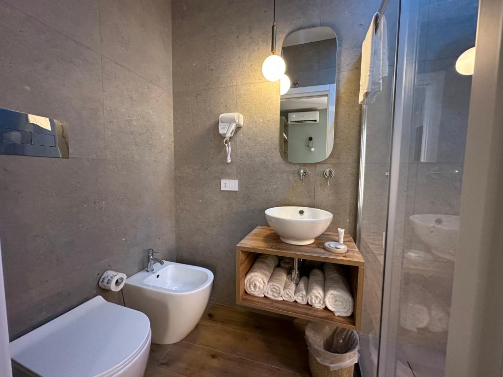a bathroom with a toilet and a sink and a shower at Krysos Luxury Rooms in Agrigento