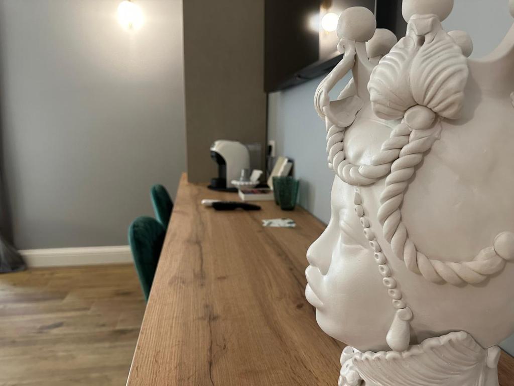 a white sculpture of a woman sitting on a table at Krysos Luxury Rooms in Agrigento