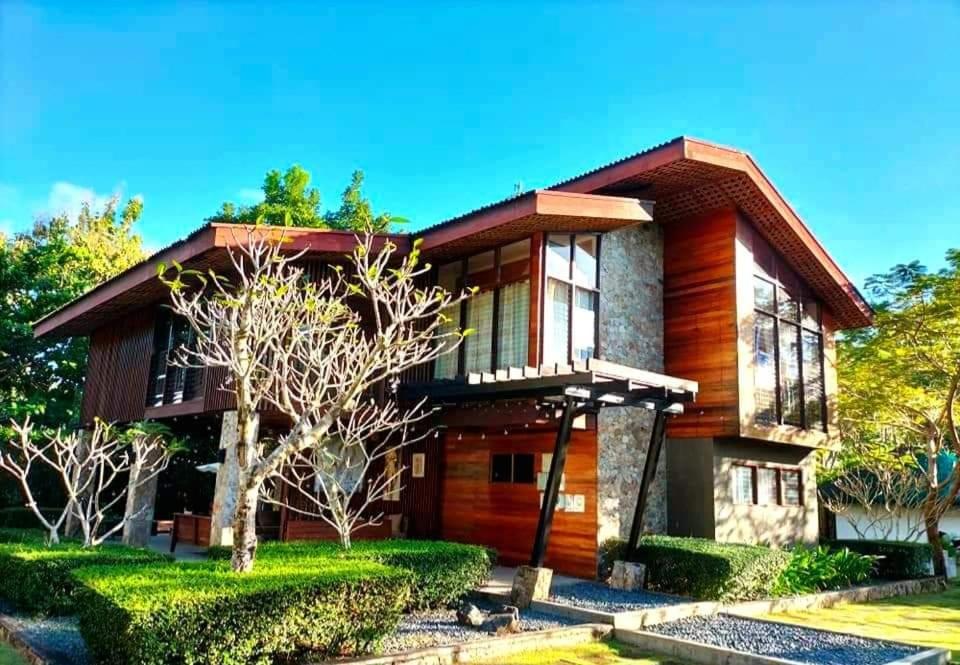 uma casa de madeira com paisagismo em Nivana Spa & Resort em Romblon