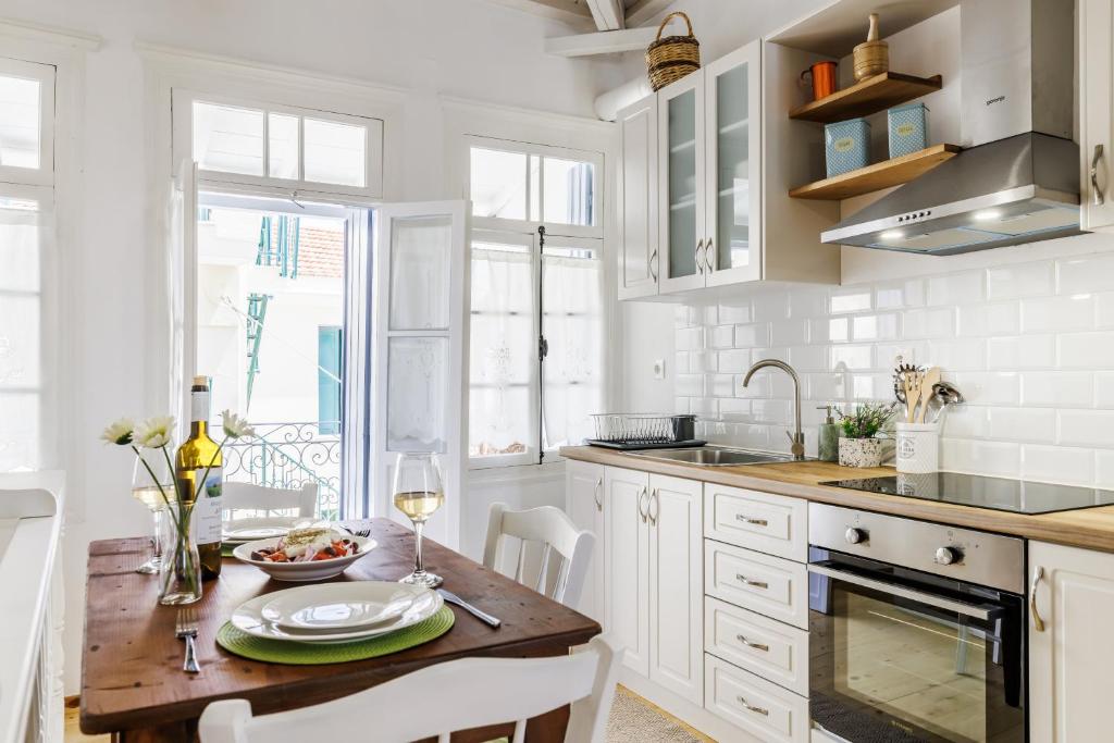 uma cozinha com armários brancos e uma mesa de madeira em AIKATERINI'S House em Skopelos Town