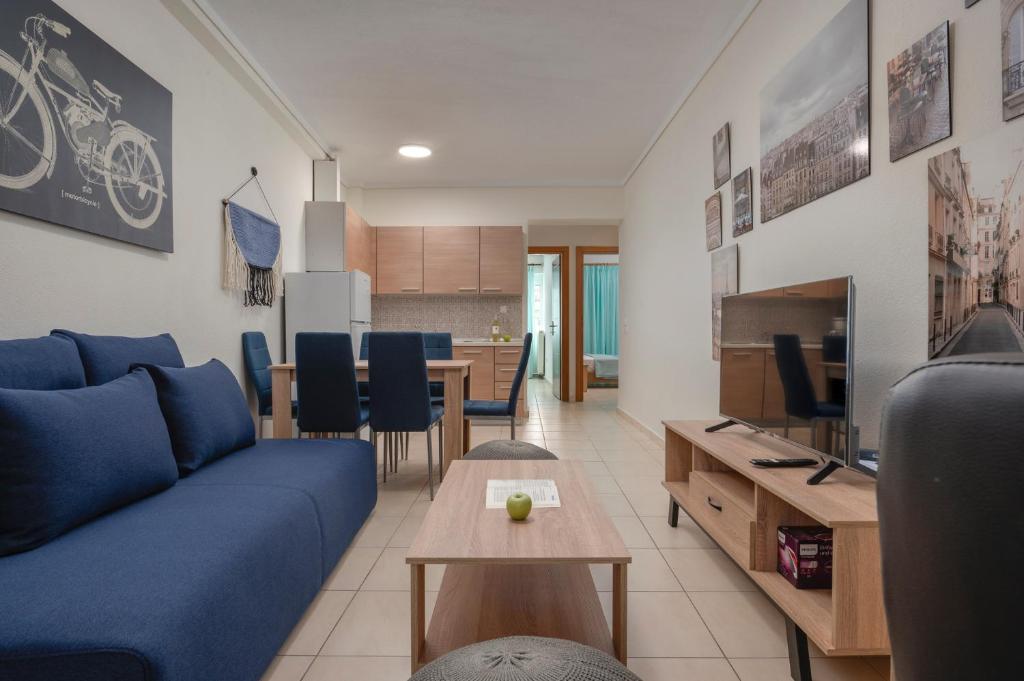 een woonkamer met een blauwe bank en een tafel bij Kosmos Service Apartment Family City Center 4C in Thessaloniki