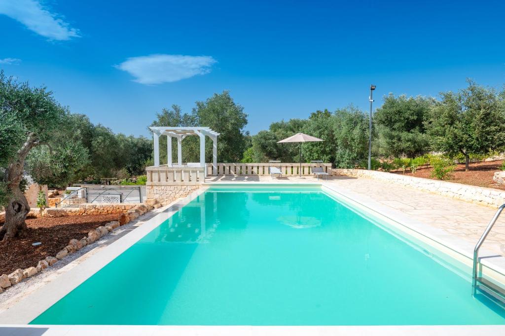 einen Pool im Hinterhof mit blauem Pool in der Unterkunft Trullo Encanto with pool in Ceglie Messapica