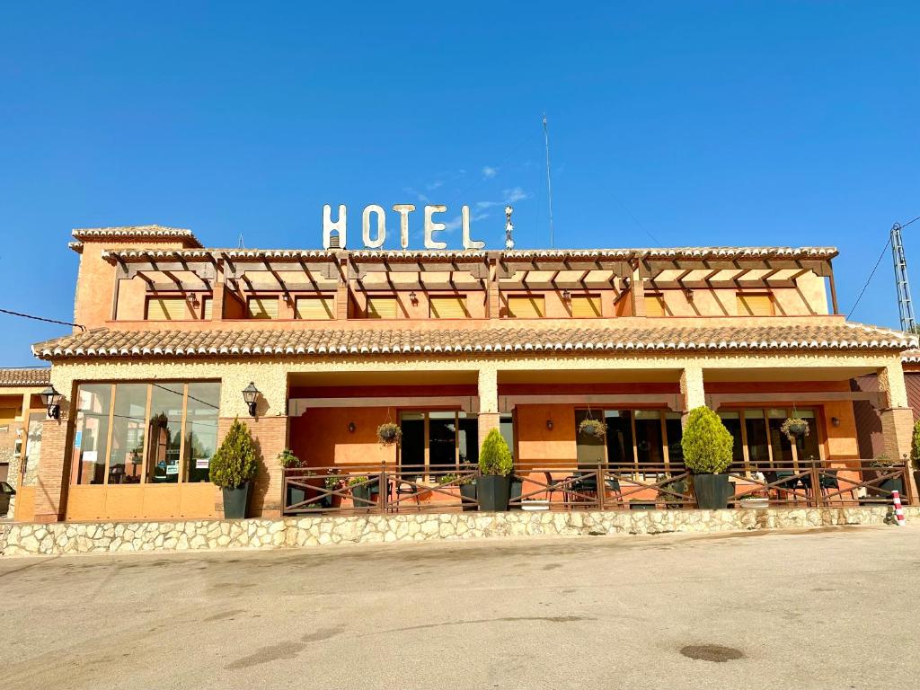 a hotel building with a sign on top of it at Hotel Restaurante Los Caños de la Alcaiceria in Alhama de Granada