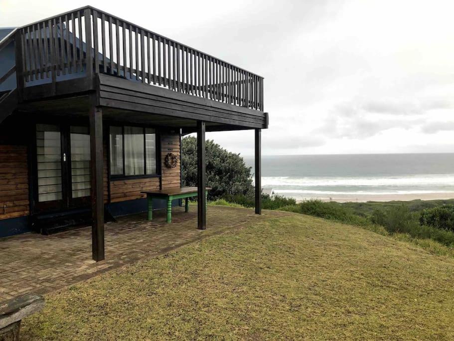 a small building with a bench on top of a hill at Emma's Beach Cottage in Groot Brak Rivier