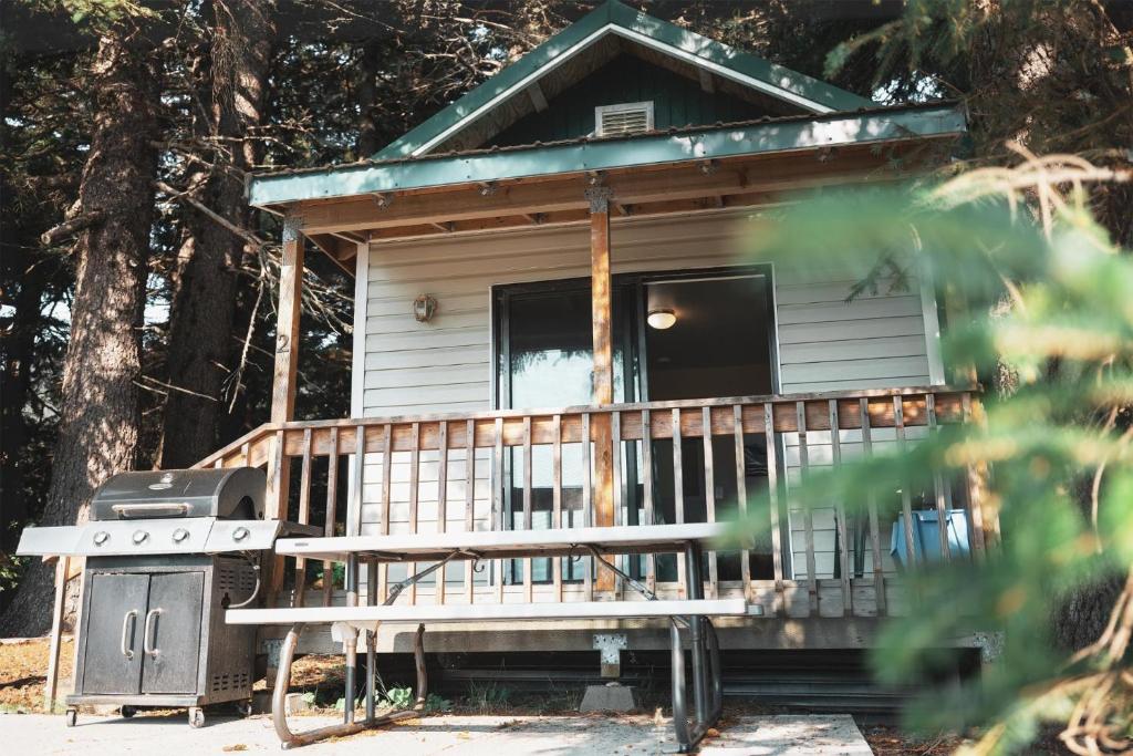una casa pequeña con porche y parrilla en Cabin 1 Lynn View Lodge, en Haines