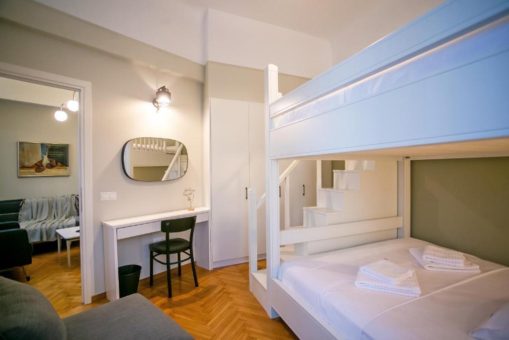 - une chambre avec des lits superposés et un bureau dans l'établissement Thalia by Heloni Apartments, à Athènes