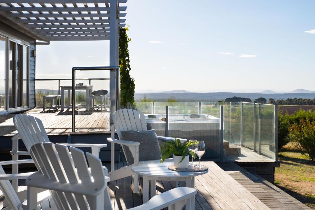 un patio con sillas blancas y una mesa en una terraza en Musk Springs, en Bullarto