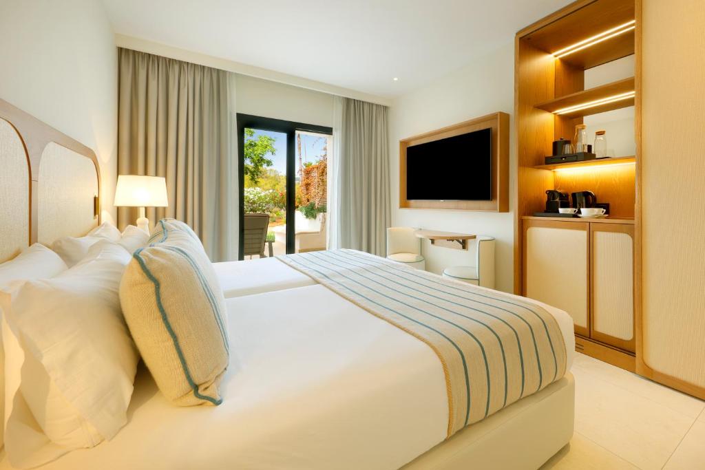 a bedroom with a large white bed and a television at The Signature Level at TRS Ibiza Hotel - All Inclusive Adults Only - Entrance to Clubs included in San Antonio