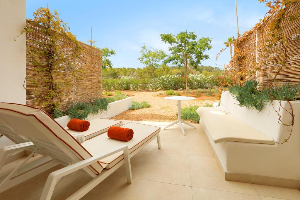 a patio with two chairs and a table and a table at The Signature Level at TRS Ibiza Hotel - All Inclusive Adults Only - Entrance to Clubs included in San Antonio