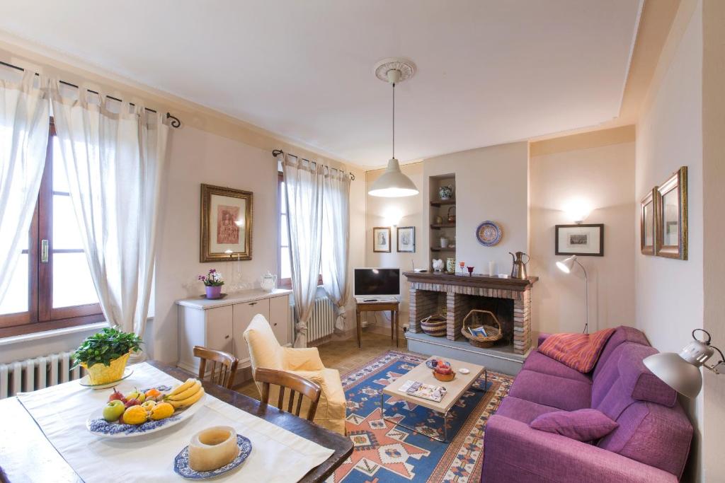 sala de estar con sofá púrpura y mesa en Appartamenti Belvedere, en Cortona
