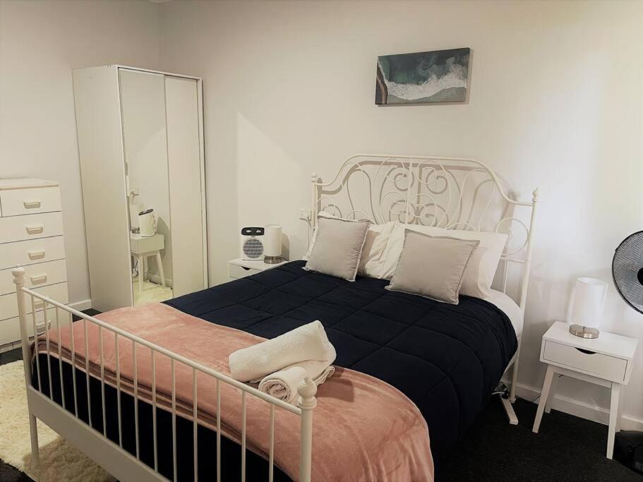 a bedroom with a black and white bed and a mirror at Six By The Beach in Esperance