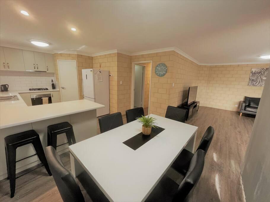 a kitchen and dining room with a white table and chairs at Stay By The Sea Esperance in Esperance