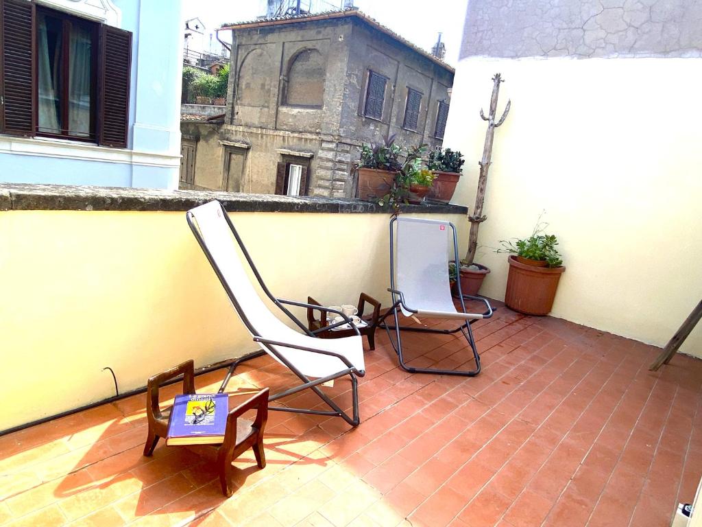 2 Stühle und ein Tisch auf dem Balkon in der Unterkunft Terraces under the Moon in Rom