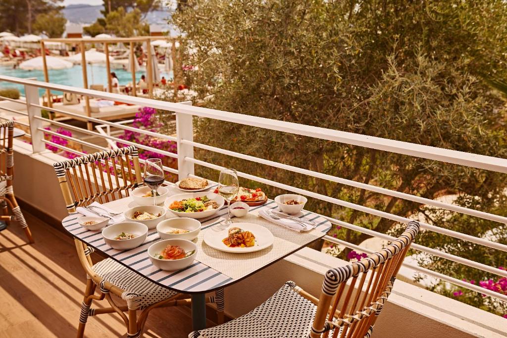 a table with plates of food on a balcony at The Signature Level at TRS Ibiza Hotel - All Inclusive Adults Only - Entrance to Clubs included in San Antonio
