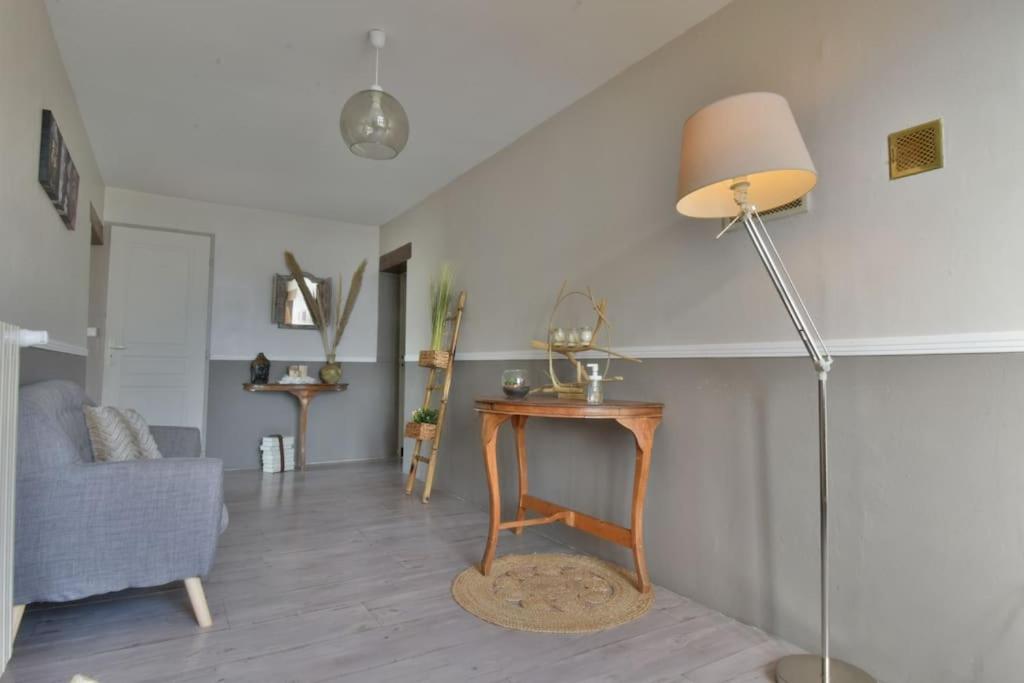 a living room with a table and a lamp at Gite de groupe &quot;L&#39;Unisson&quot; Domaine La Rose des Vents in Castelnau-sur-lʼAuvignon