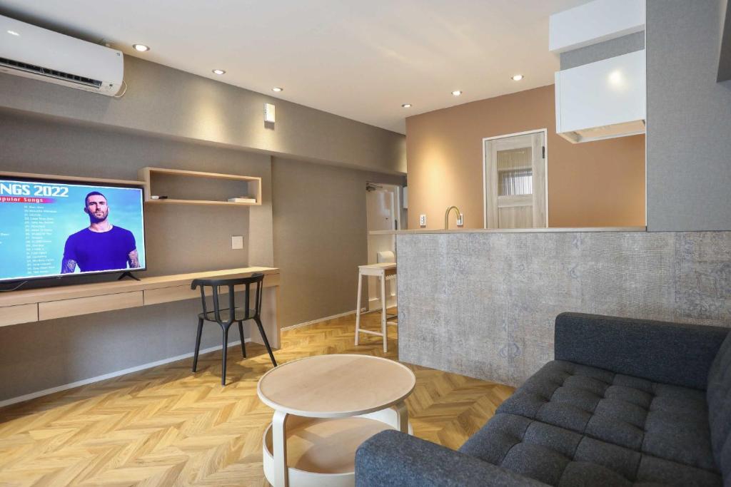 ein Wohnzimmer mit einem Sofa, einem TV und einer Bar in der Unterkunft ZDT-406 in Tokio