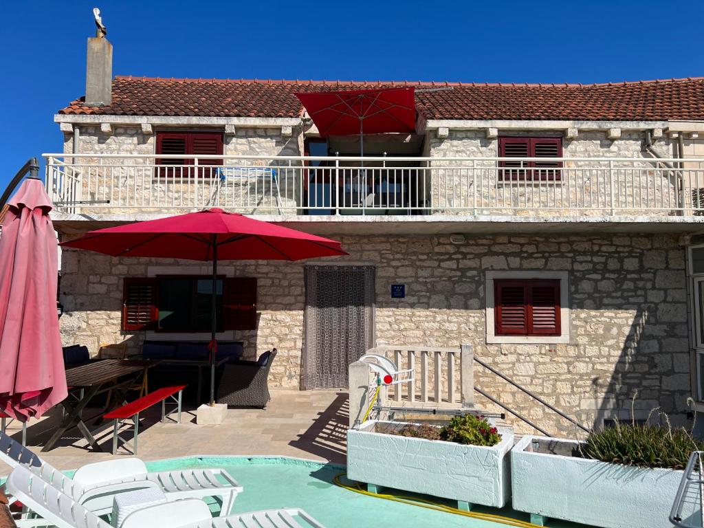 uma casa com piscina e guarda-sol vermelho em Rafa´s house em Selca