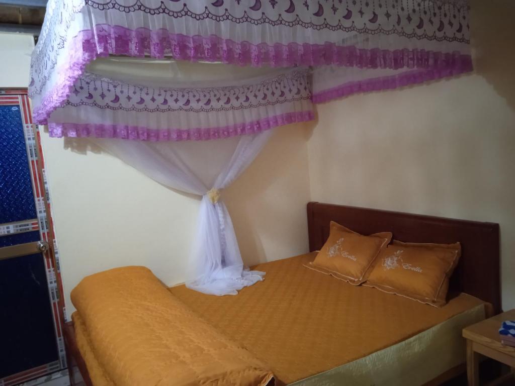a bedroom with a bed with a canopy and a window at Homestay Ngọc Thủy Điểm dừng chân lên Đồi Mâm Xôi in Mù Cang Chải