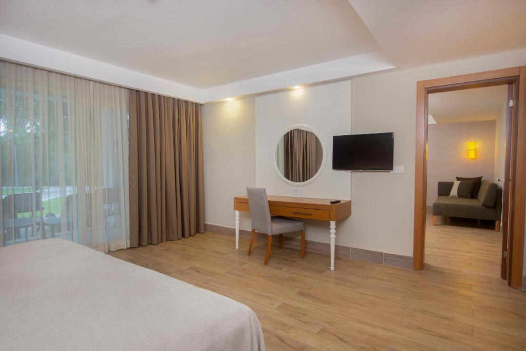 a hotel room with a desk and a television at Sherwood Exclusive Kemer - Kids Concept in Kemer