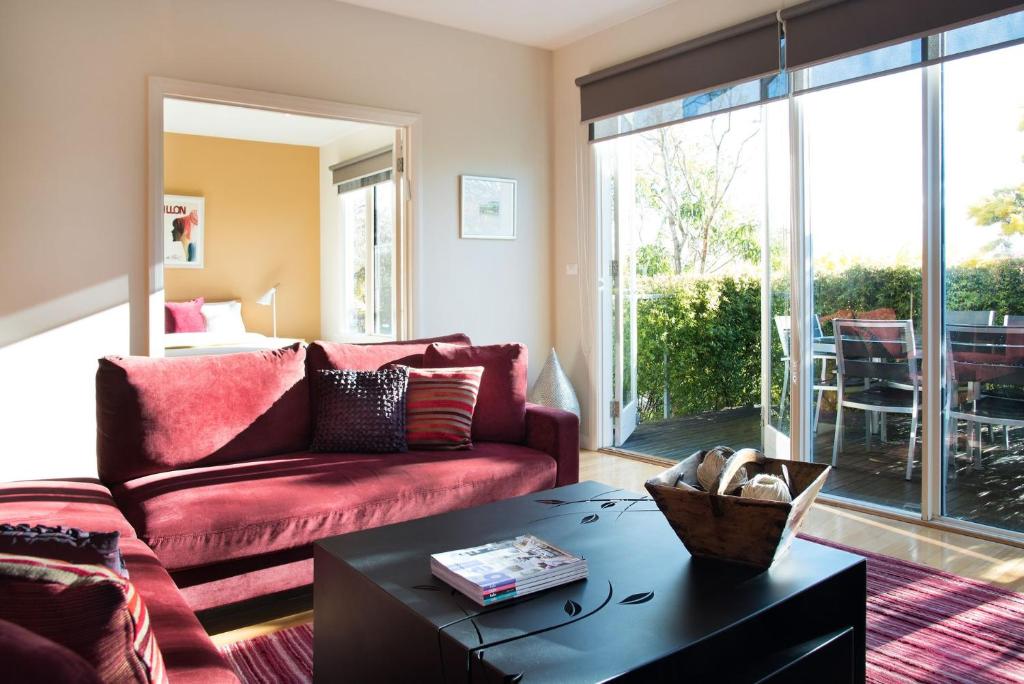 a living room with a red couch and a table at Orford Panache in Daylesford