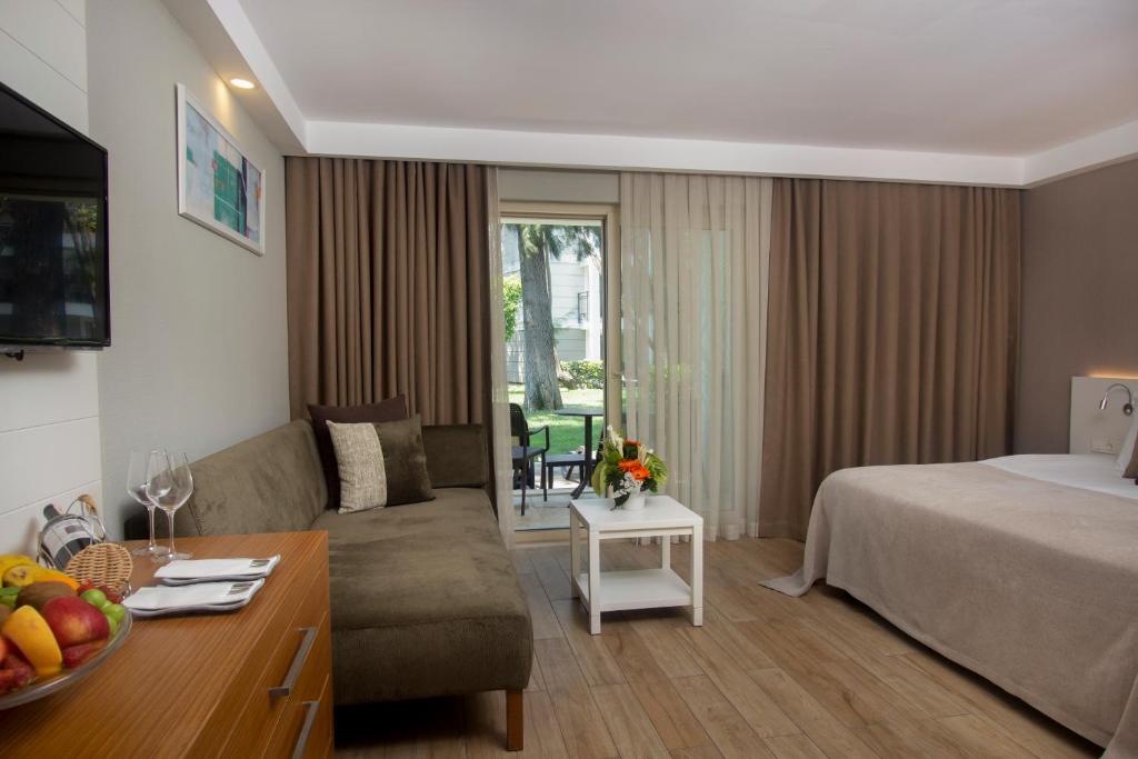 a hotel room with a bed and a couch at Sherwood Exclusive Kemer - Kids Concept in Kemer