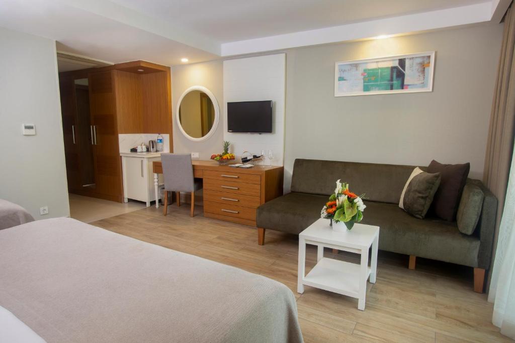 a hotel room with a bed and a couch and a table at Sherwood Exclusive Kemer - Kids Concept in Kemer