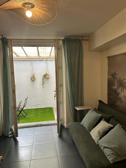 un salon avec un canapé et une grande fenêtre dans l'établissement Le petit Championnet T2, à Grenoble