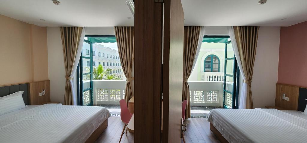 1 dormitorio con 2 camas y ventana grande en Chloe Marina Phu Quoc, en Phu Quoc