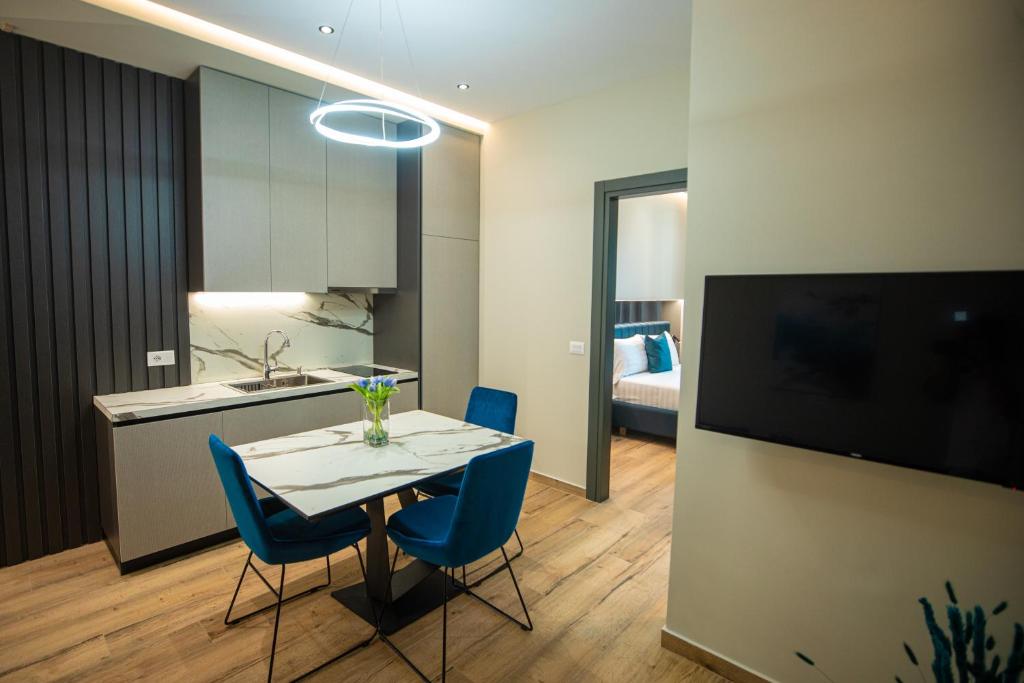 a kitchen and dining room with a table and blue chairs at Vlore Luxury Apartaments "FAEL" in Vlorë