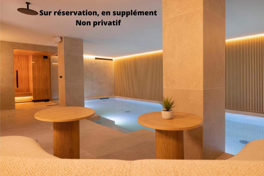 une piscine au milieu d'une pièce avec deux tables dans l'établissement Hôtel Esté, à Paris